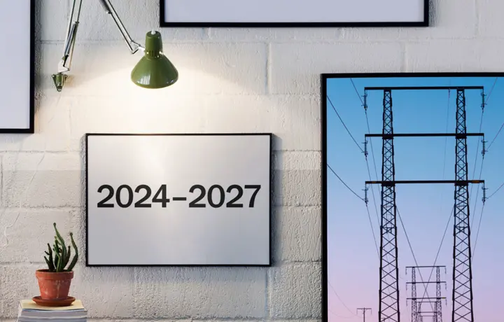 Fotografi som visar en vägg med tavlor där en av tavlan har årtalen 2024-2027 och den andra tavlan elledningar.